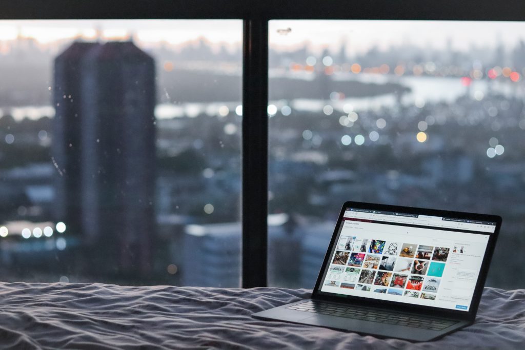 Laptop on bed in apartment with sky view